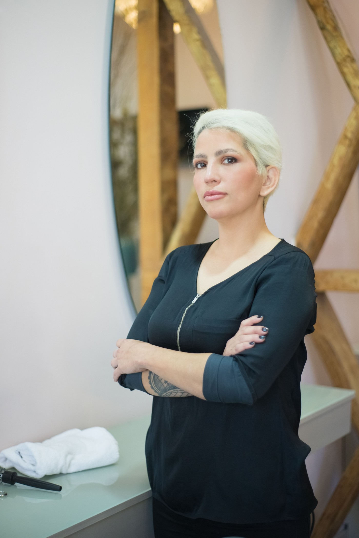 Maja, frisør i Studio Eik, i dagslys ved speilet